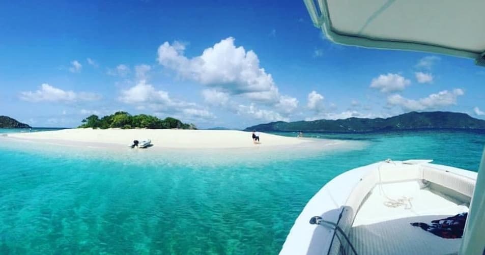 Small boat near sandbar in St. Thomas turquoise waters, snorkeling trip