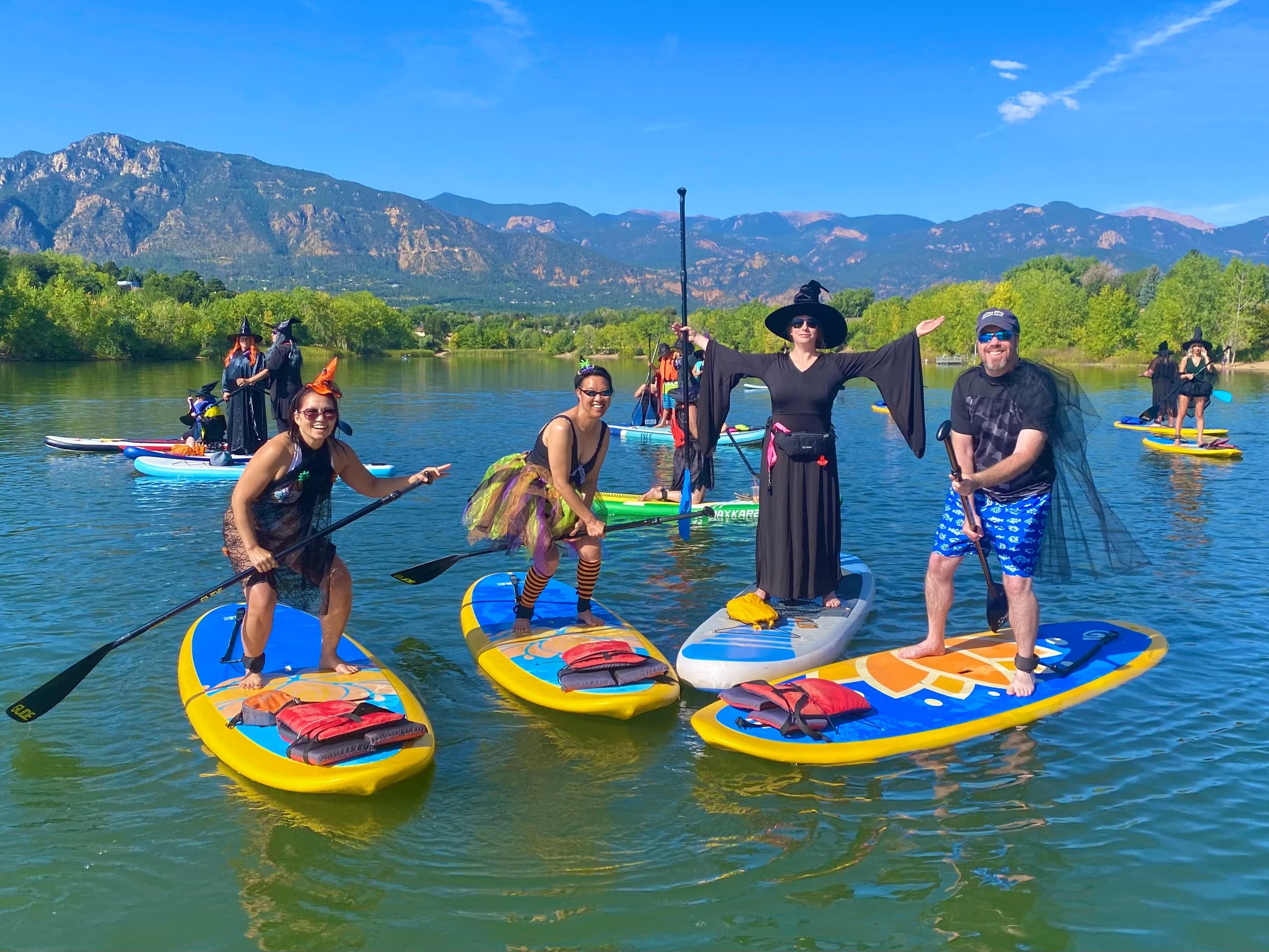 Mixed group paddleboarding on scenic mountain lake, daytime