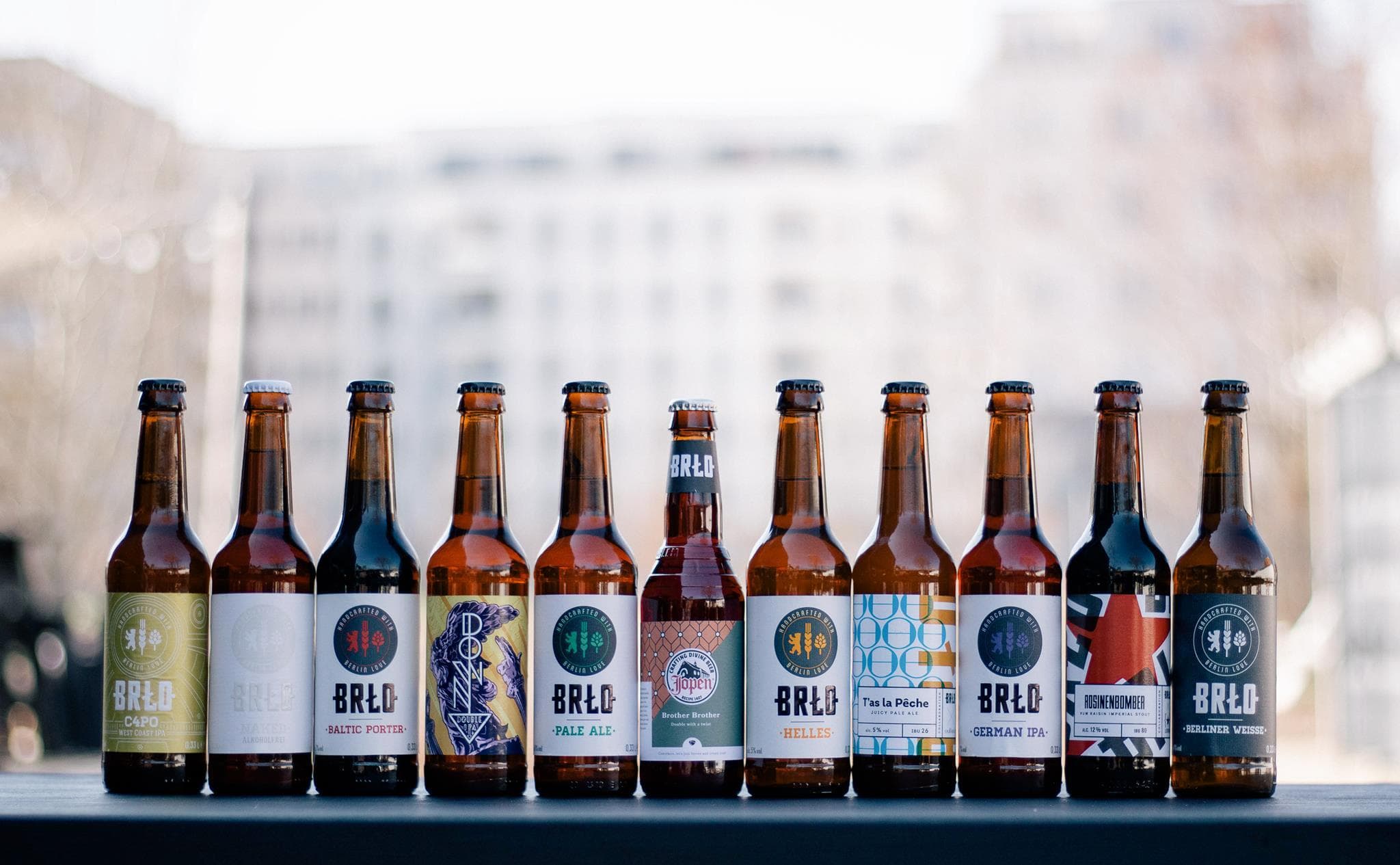 Row of BRLO bottled beers on window ledge with city view
