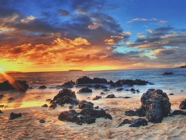 Sunset rocky shoreline with dramatic sky, scenic ocean panorama