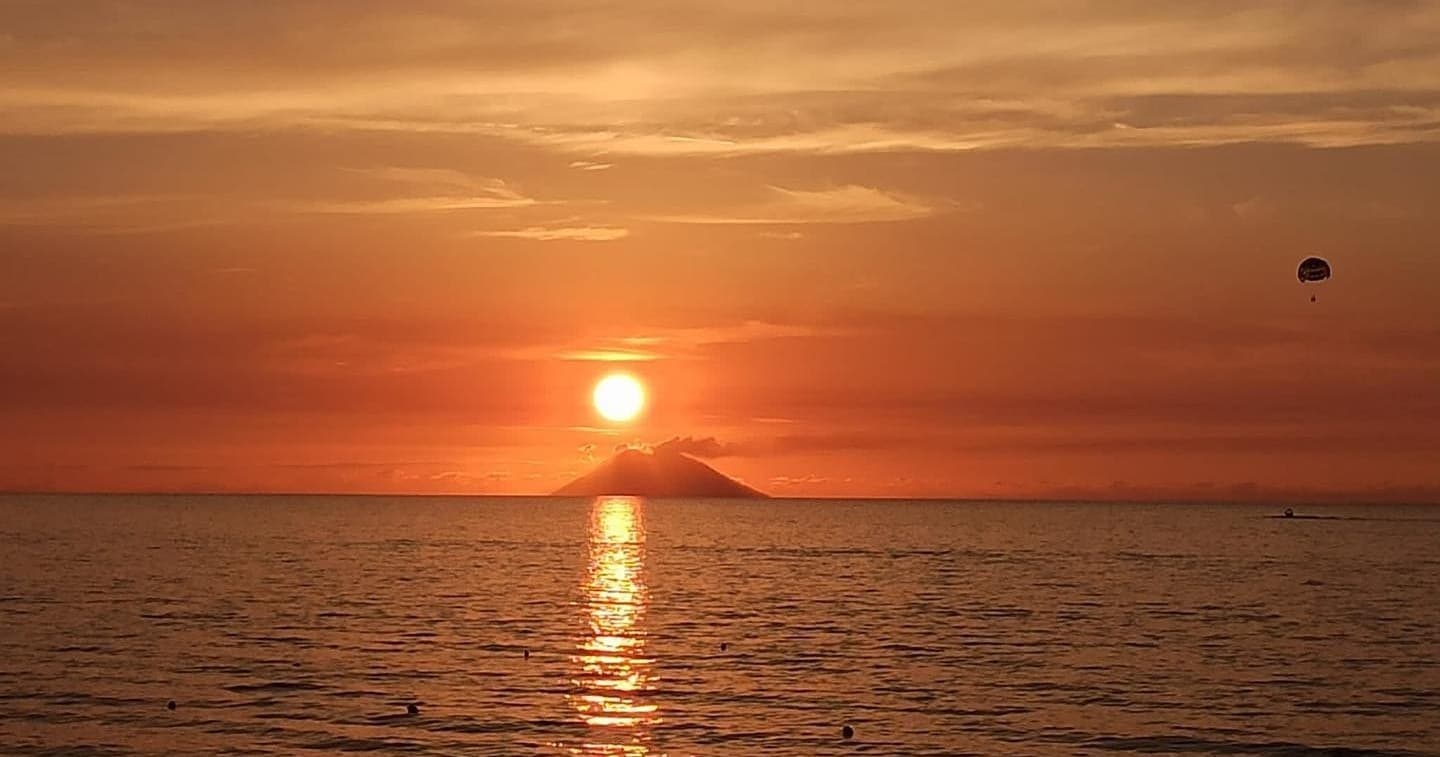 Sunset over Tyrrhenian Sea with parasailer and calm waters