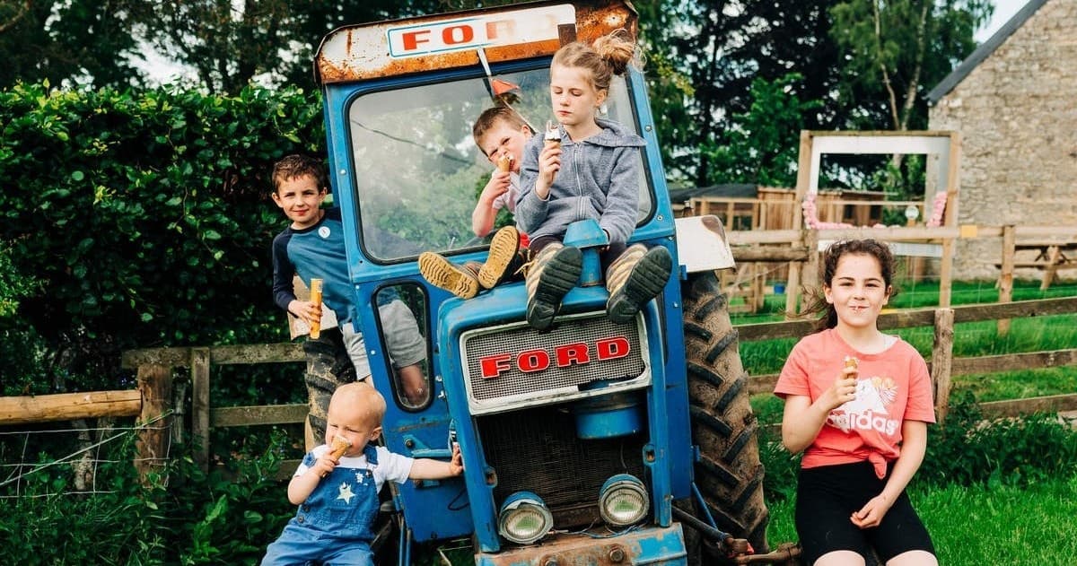 Family kids on vintage tractor at rural Jedburgh farm experience