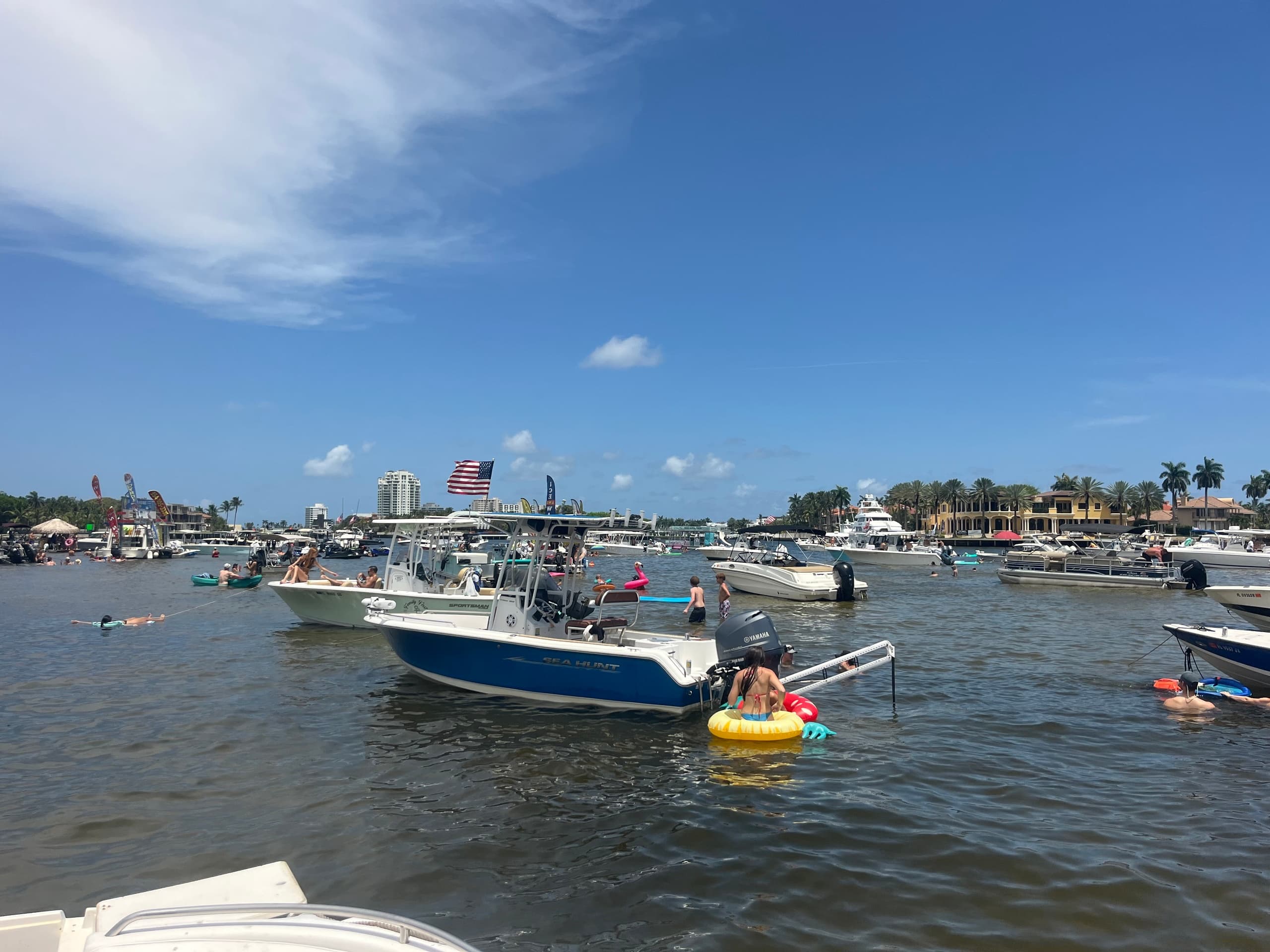 Boats anchored in bay with skyline, beach day boating