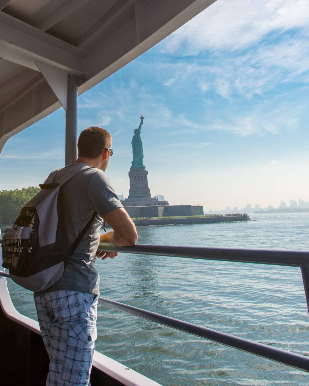 Passenger on ferry viewing Statue of Liberty across harbor