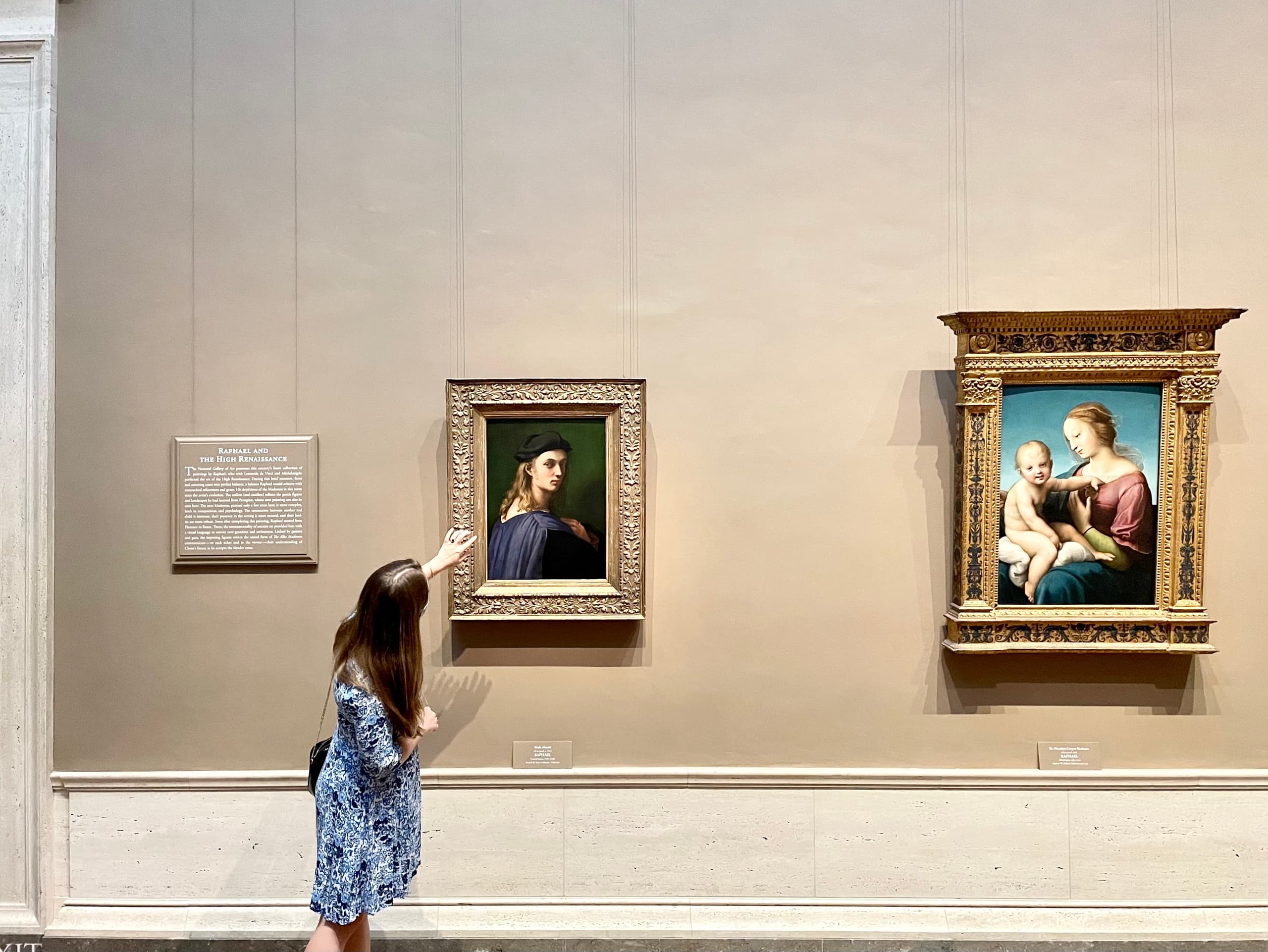Girl viewing classic paintings in museum gallery interior