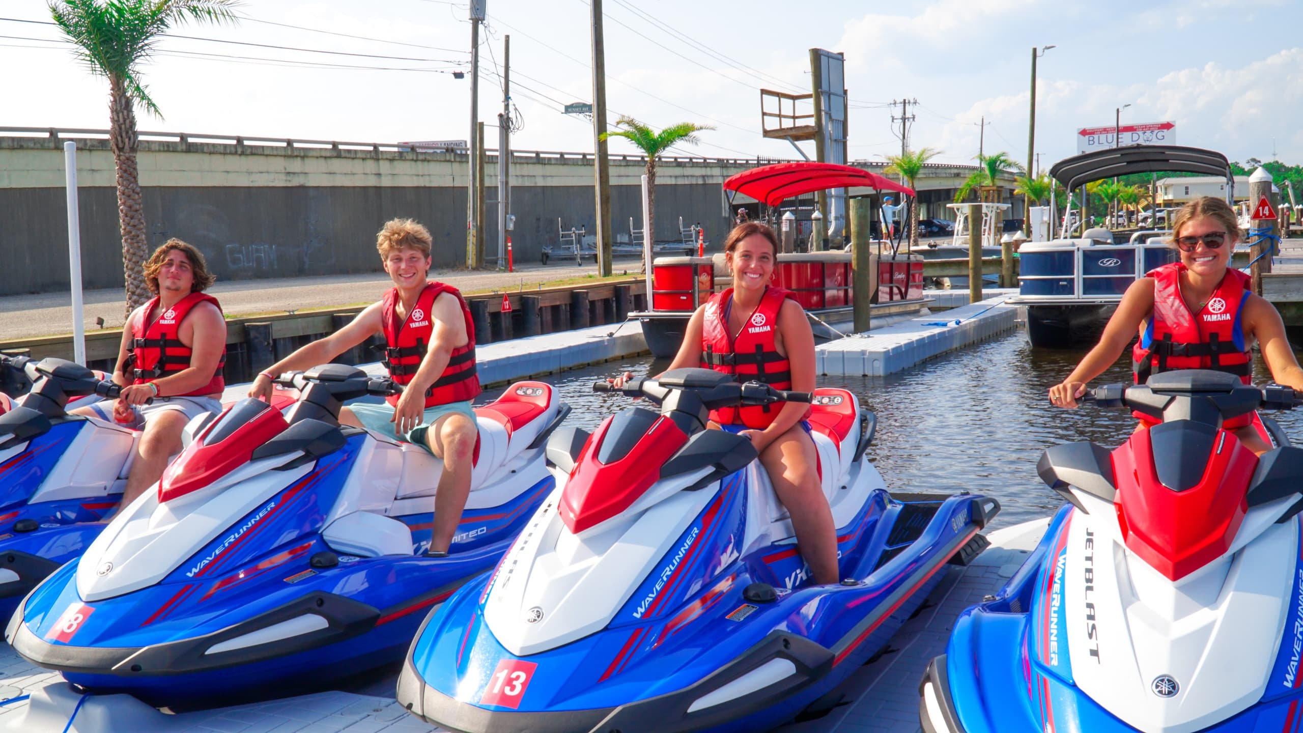Group preparing jet skis at marina dock before ocean tour