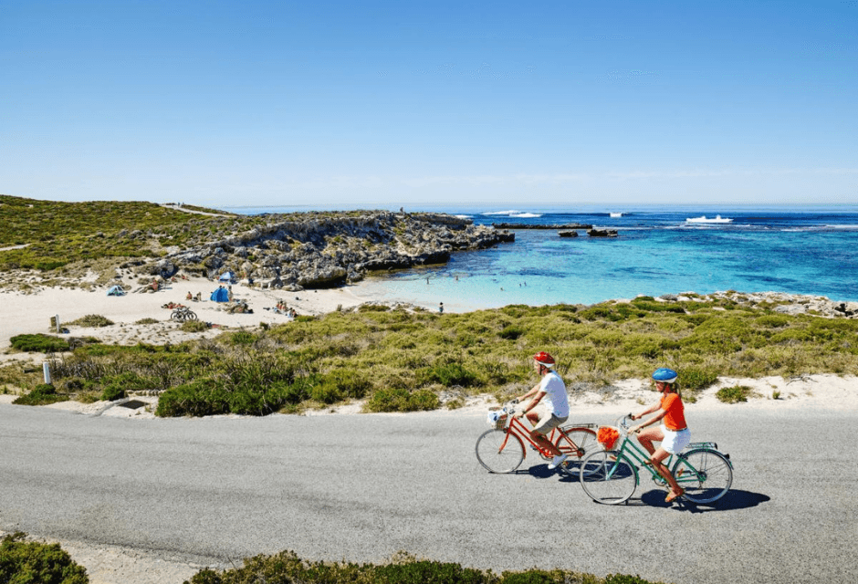 Cyclists riding coastal road past bays and beaches in Australia
