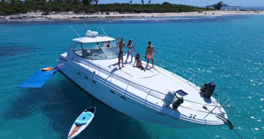 Group on yacht cruising clear blue waters, anchored near island