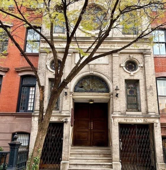 Historic brownstone entrance on tree-lined urban street facade