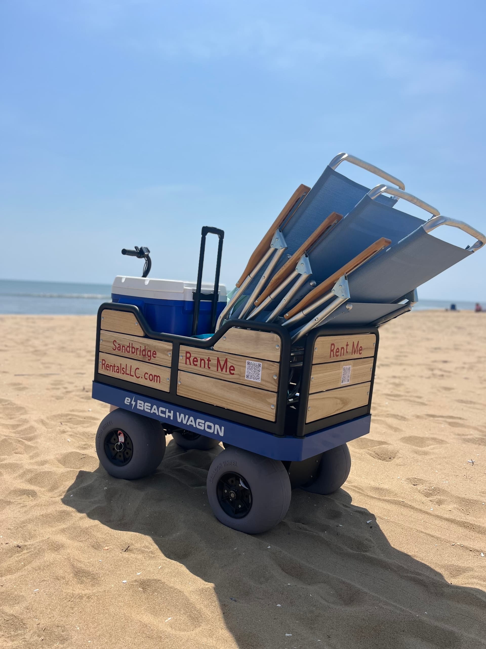 Beach wagon loaded with chairs on sandy beach shore