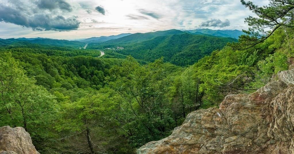 Scenic mountain overlook and hiking vista with lush forest valley