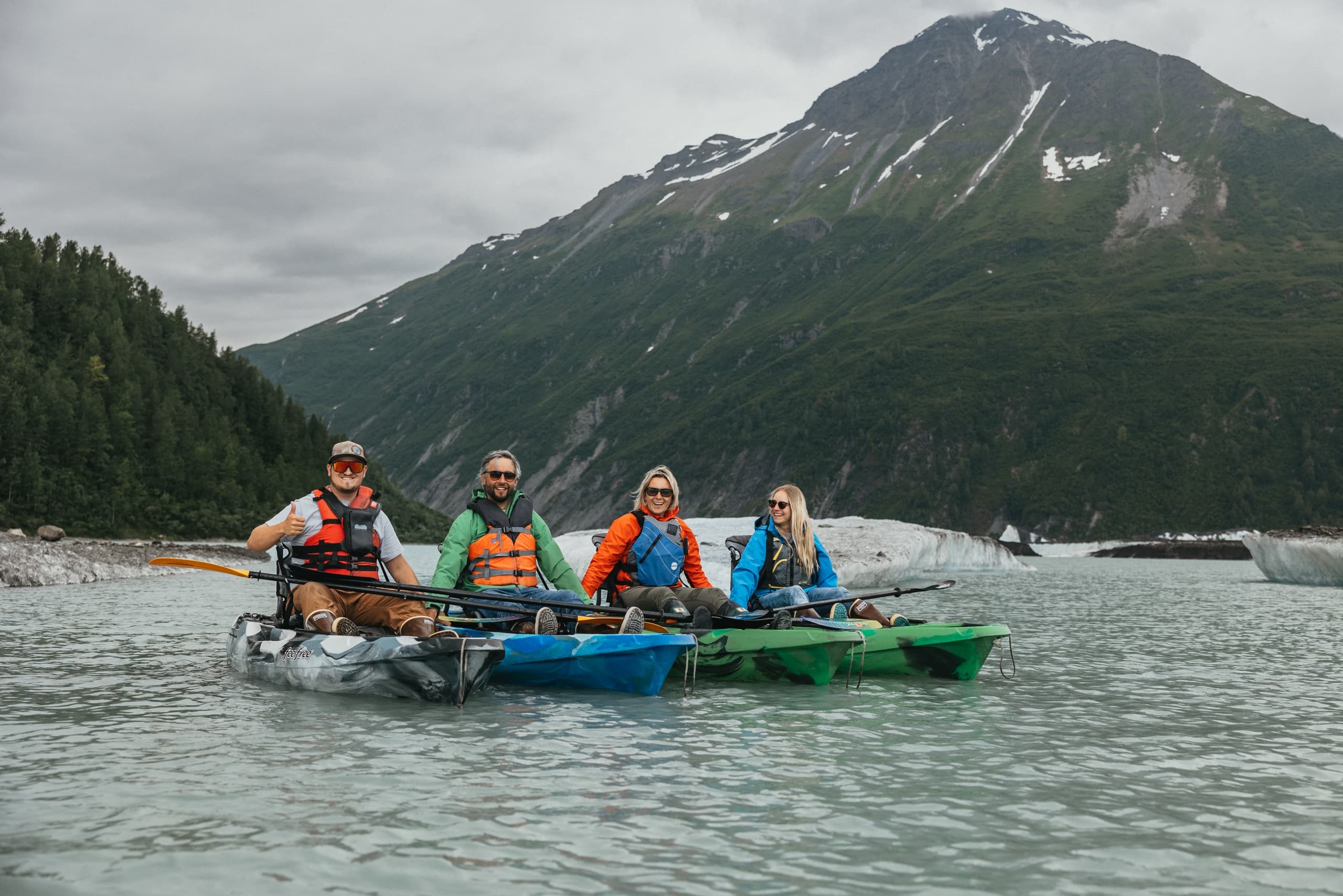 Kayakers paddling on serene mountain fjord, Alaska