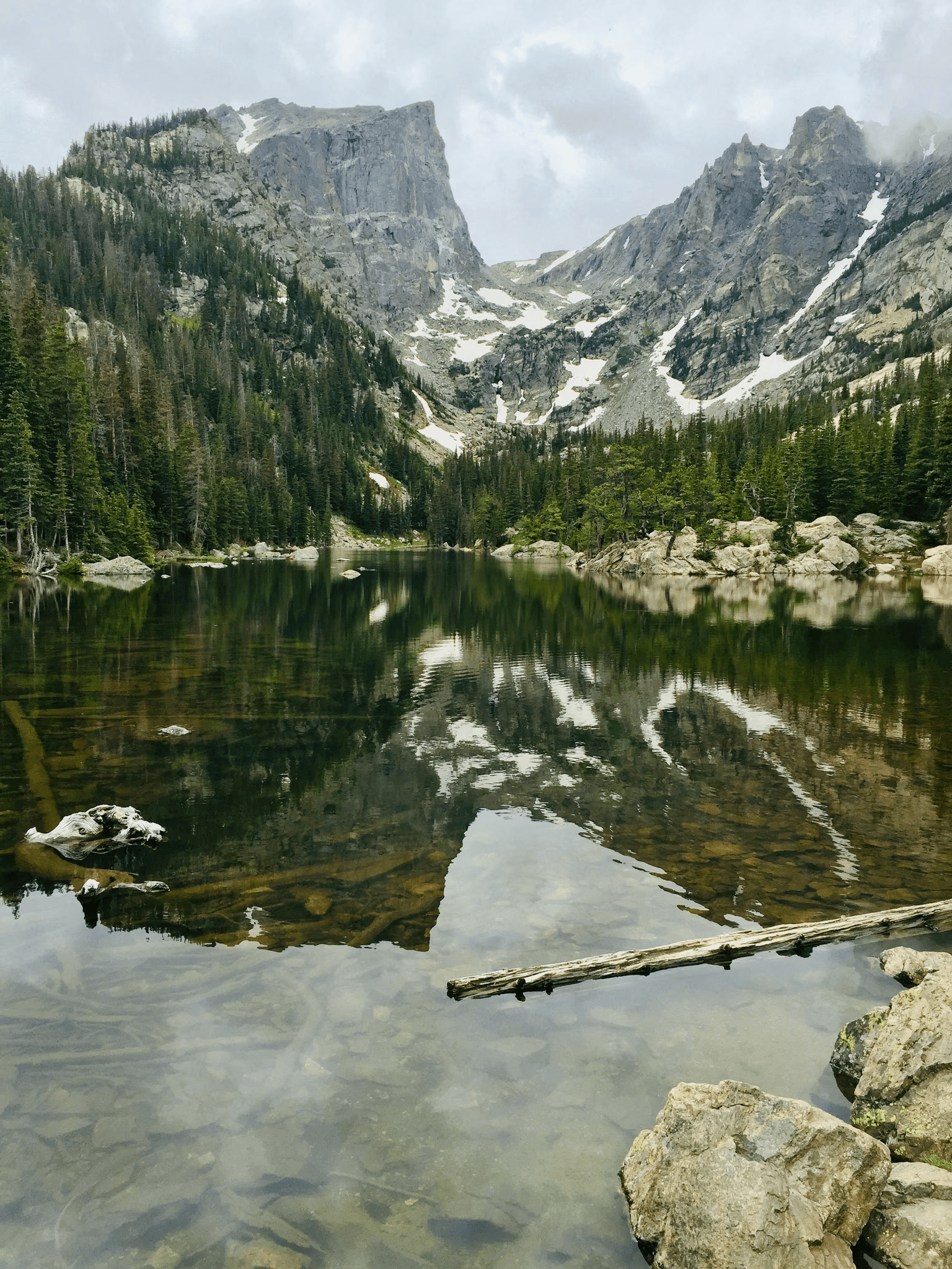 Alpine lake reflecting jagged peaks in a serene valley