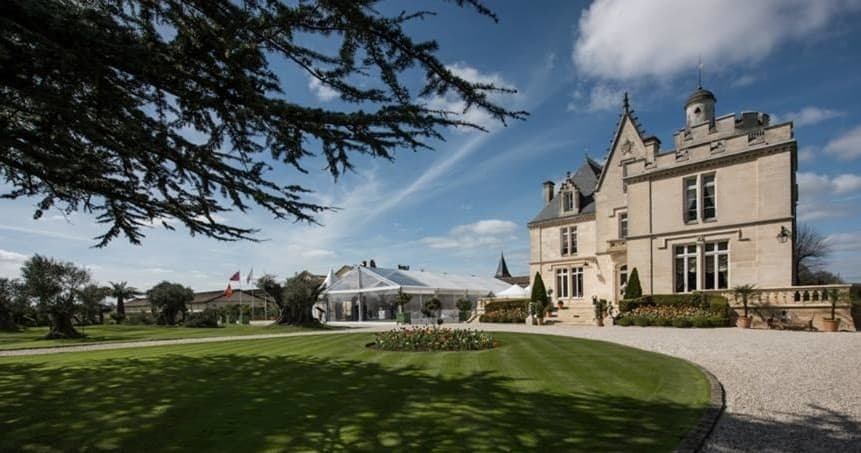 Stately château grounds and lanes under blue sky at vineyard estate