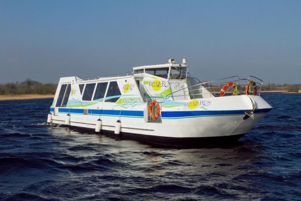 Passenger launch cutting through open river waters on tour