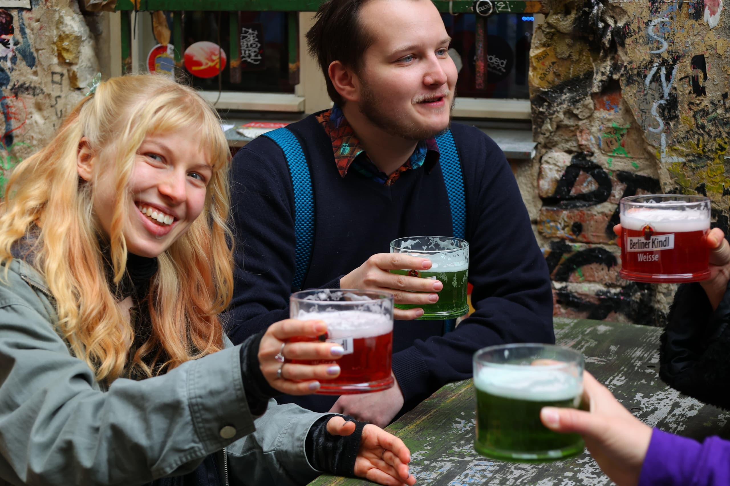 Friends toasting craft beers outdoors in Berlin street food scene