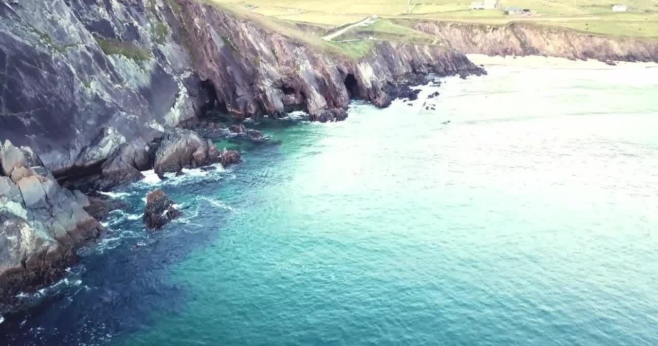 Aerial coastal cliffs and turquoise bay, ideal sea kayaking tours
