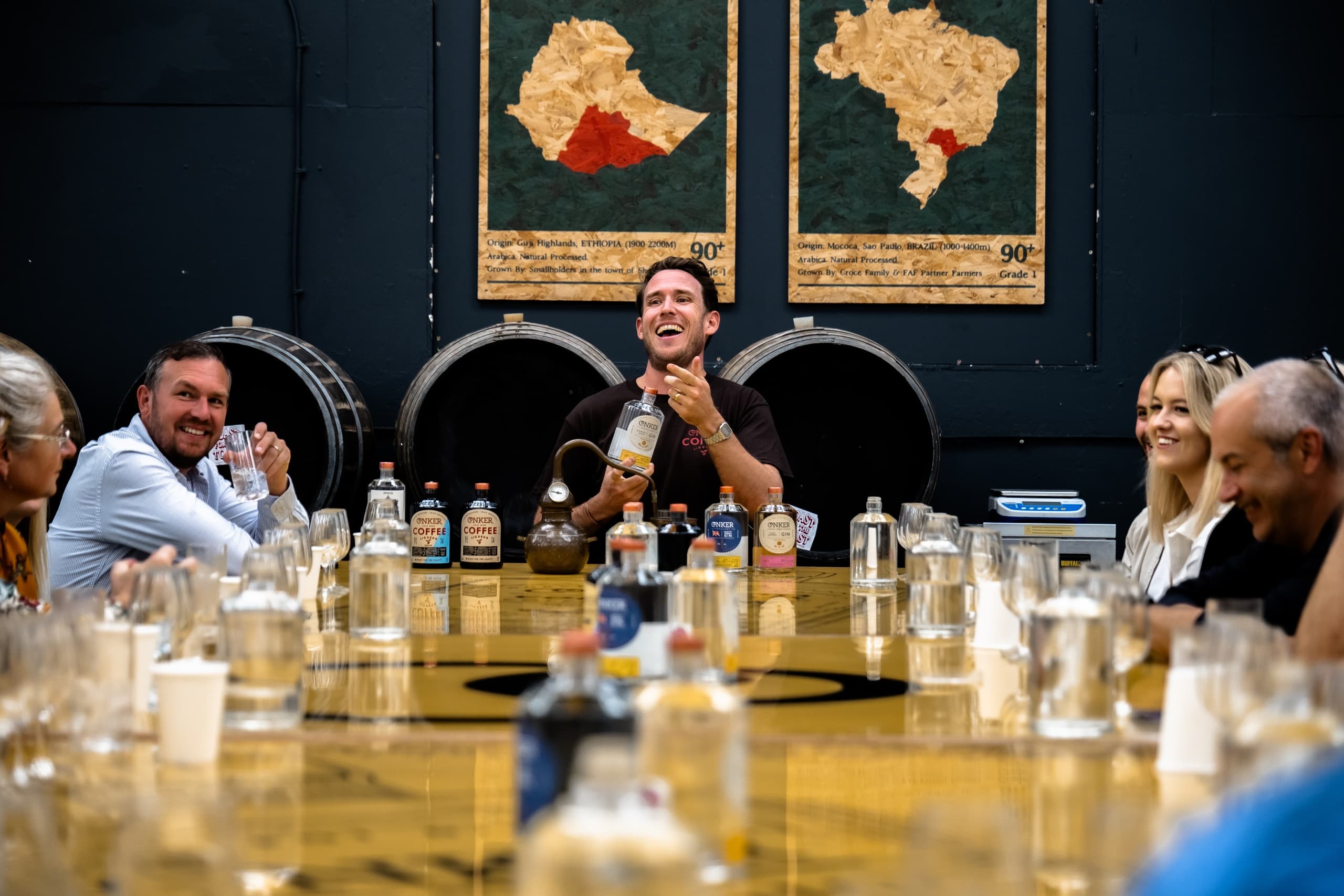 Group whisky tasting inside distillery tasting room with barrels
