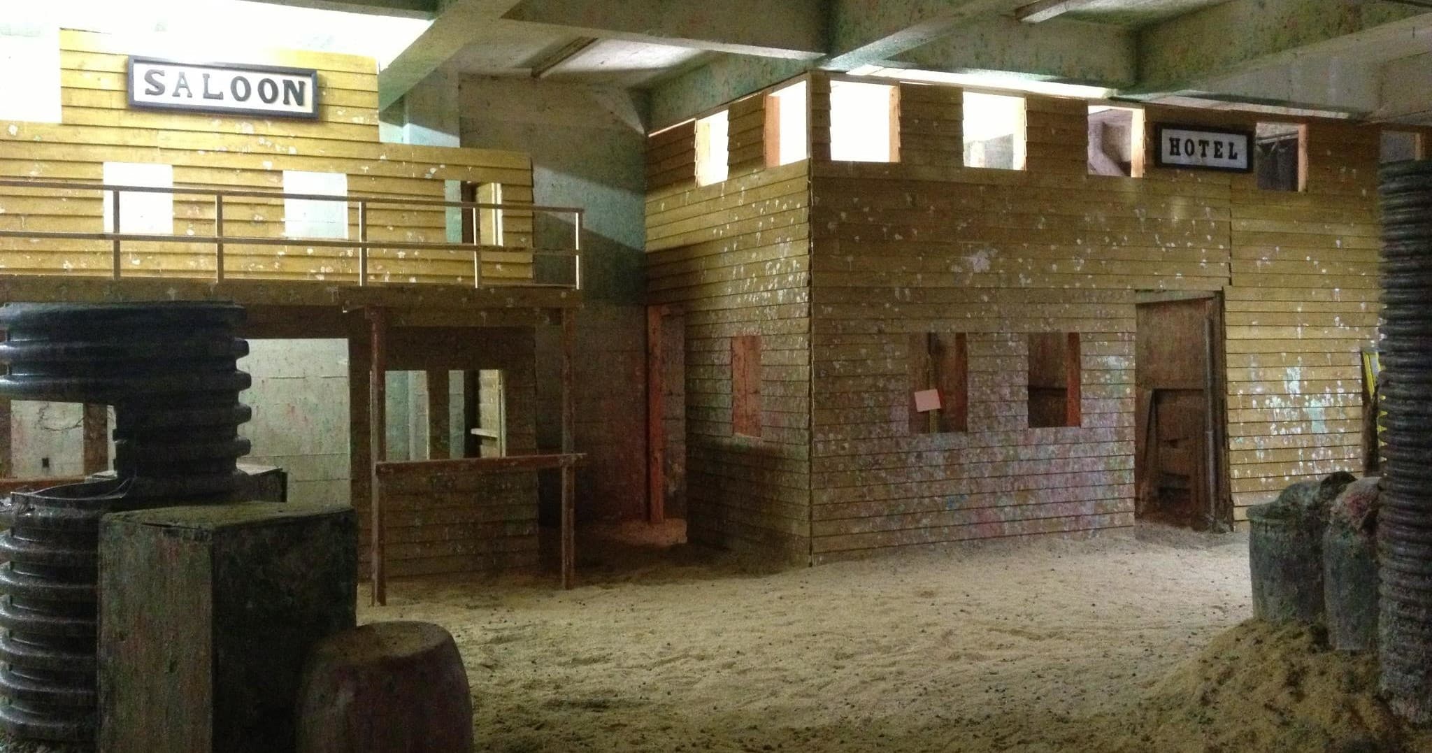 Indoor wooden saloon-style paintball field with bunkers