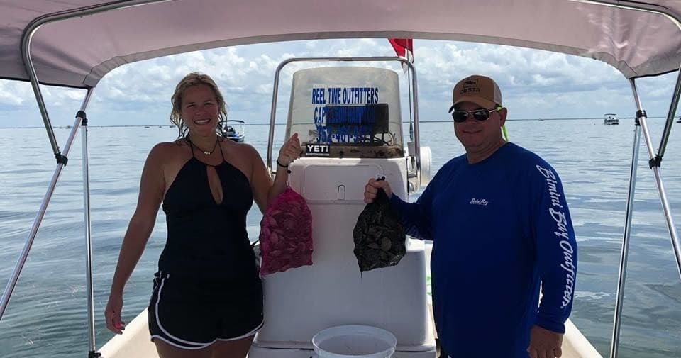 Two anglers on a charter boat posing with catch on coastal waters