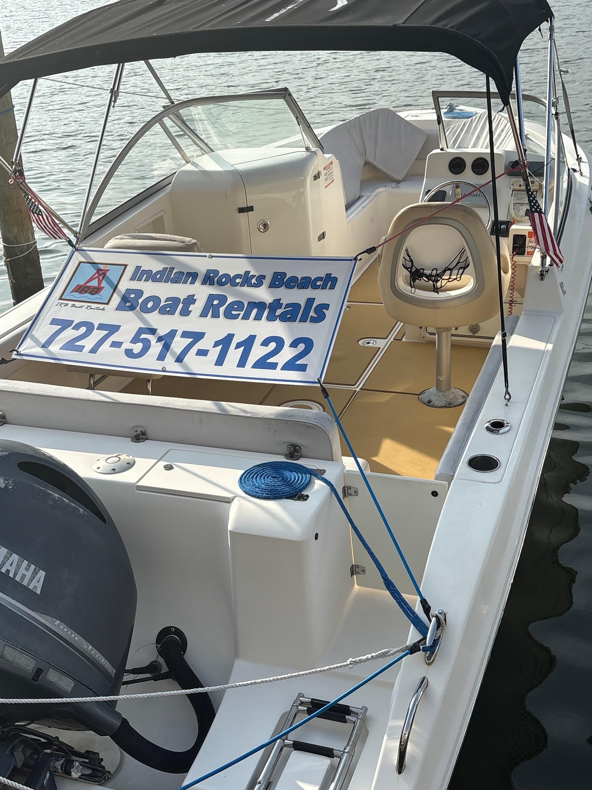 Interior cockpit of rental boat with signage at marina dock