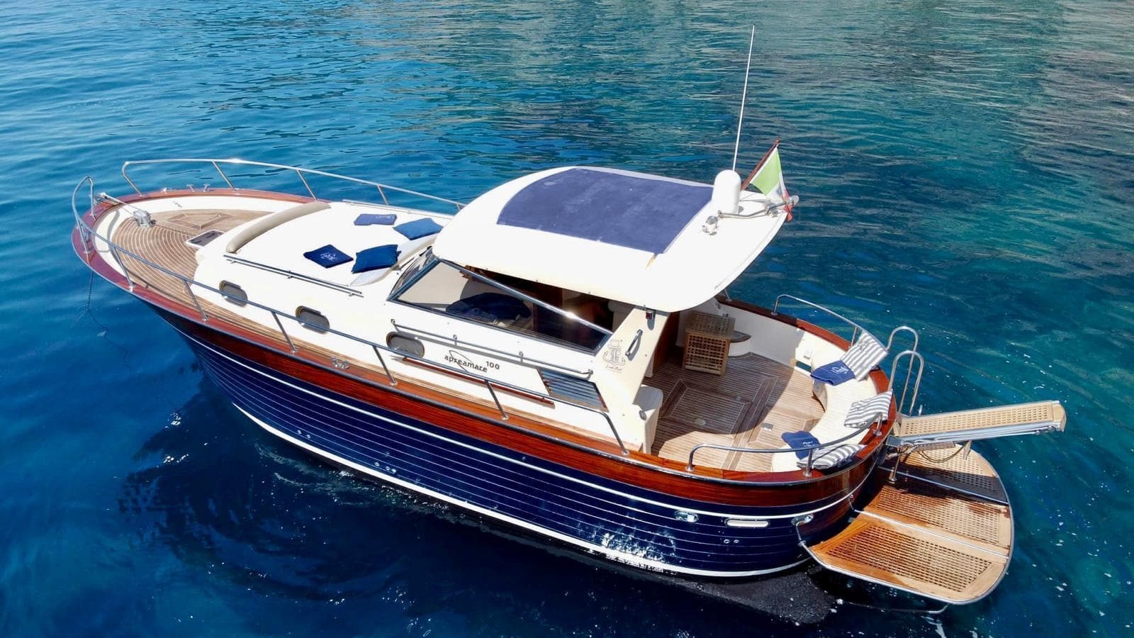 Classic wooden yacht anchored in clear turquoise coastal waters