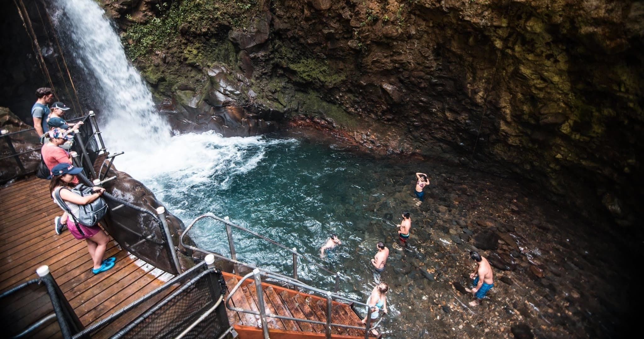 Adventurer rappelling down lush waterfall at Guachipelin canyon