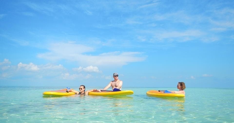Group kayaking and paddleboarding in clear tropical bay