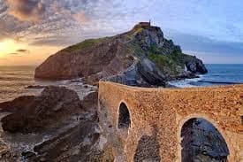 Historic island chapel reached by stone bridge on Basque coast
