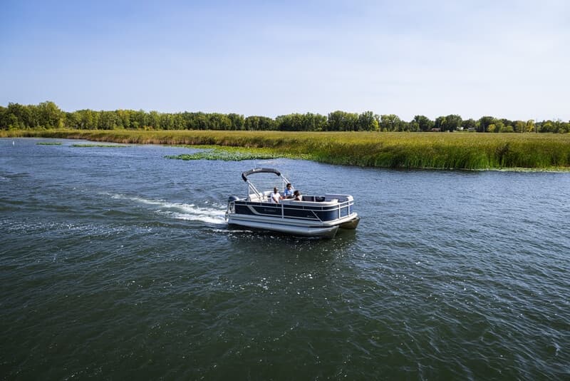 Small motorboat navigating wide scenic lake waters at speed