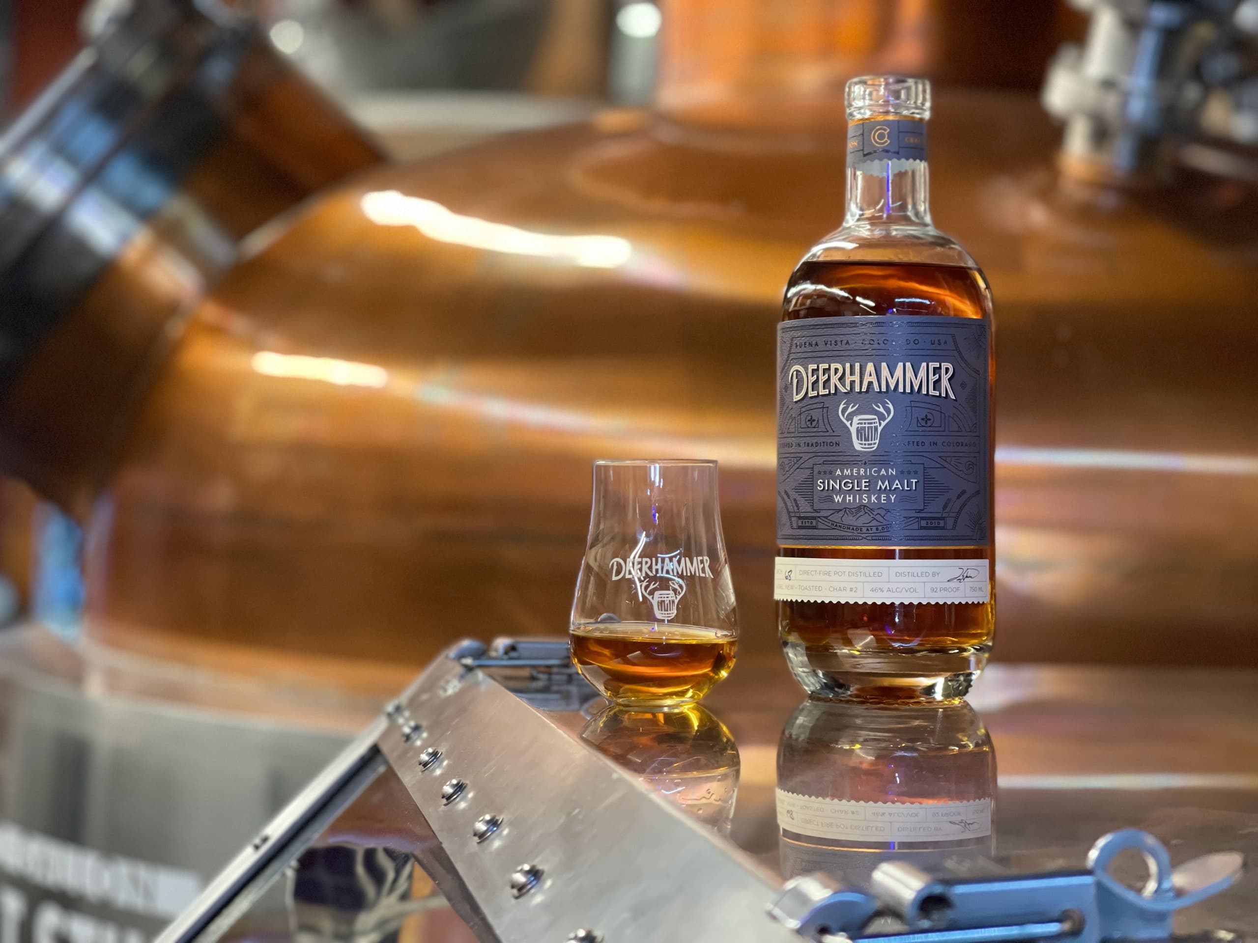 Whiskey bottle and glass in copper-still distillery tasting experience