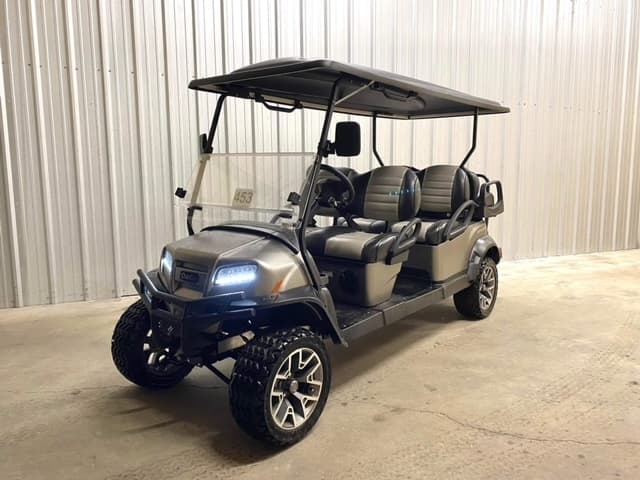 Six-seat electric golf cart parked inside storage garage