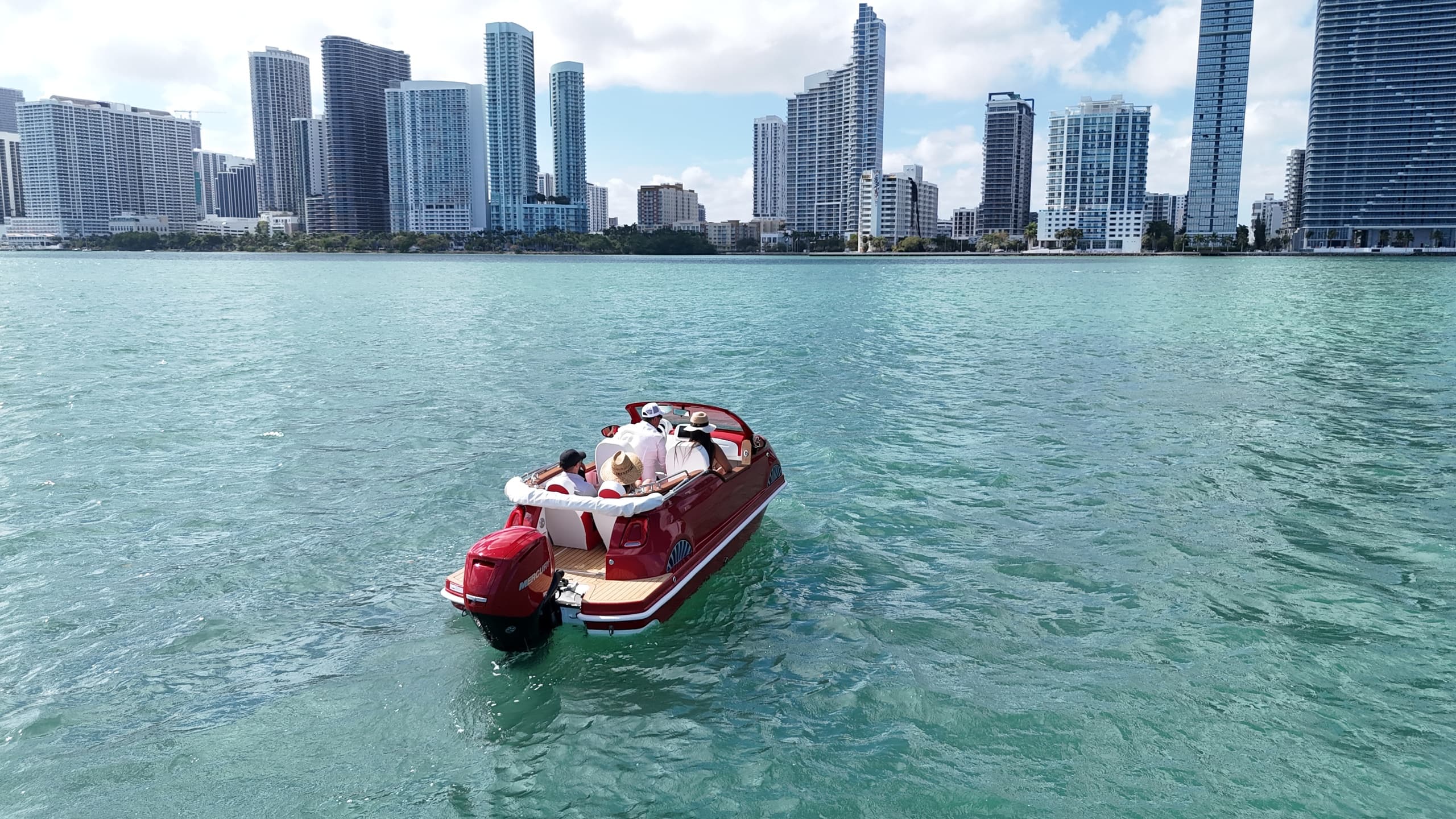 Red boat cruising in turquoise bay with Miami skyline