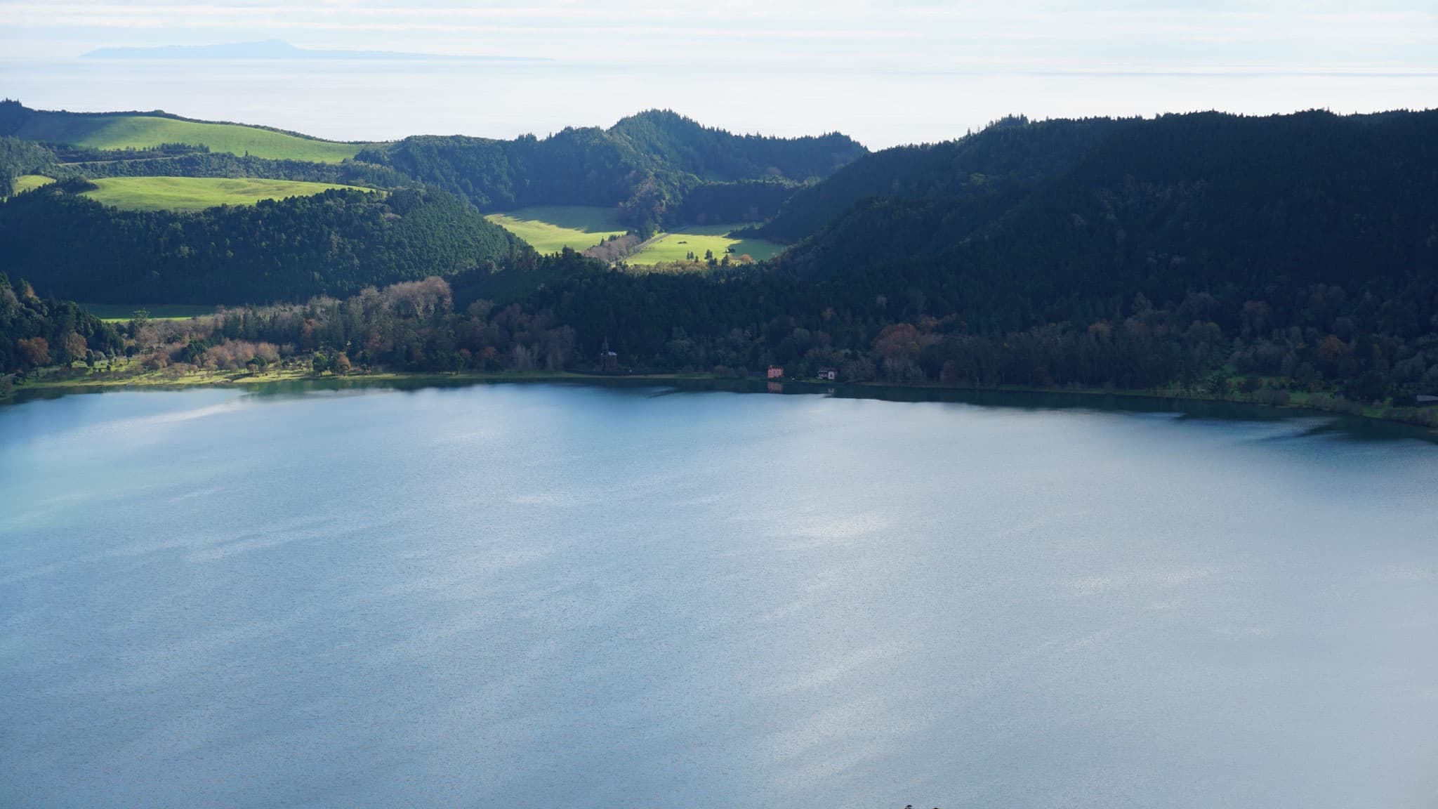Panoramic lake and rolling hills at coastal Azores viewpoint
