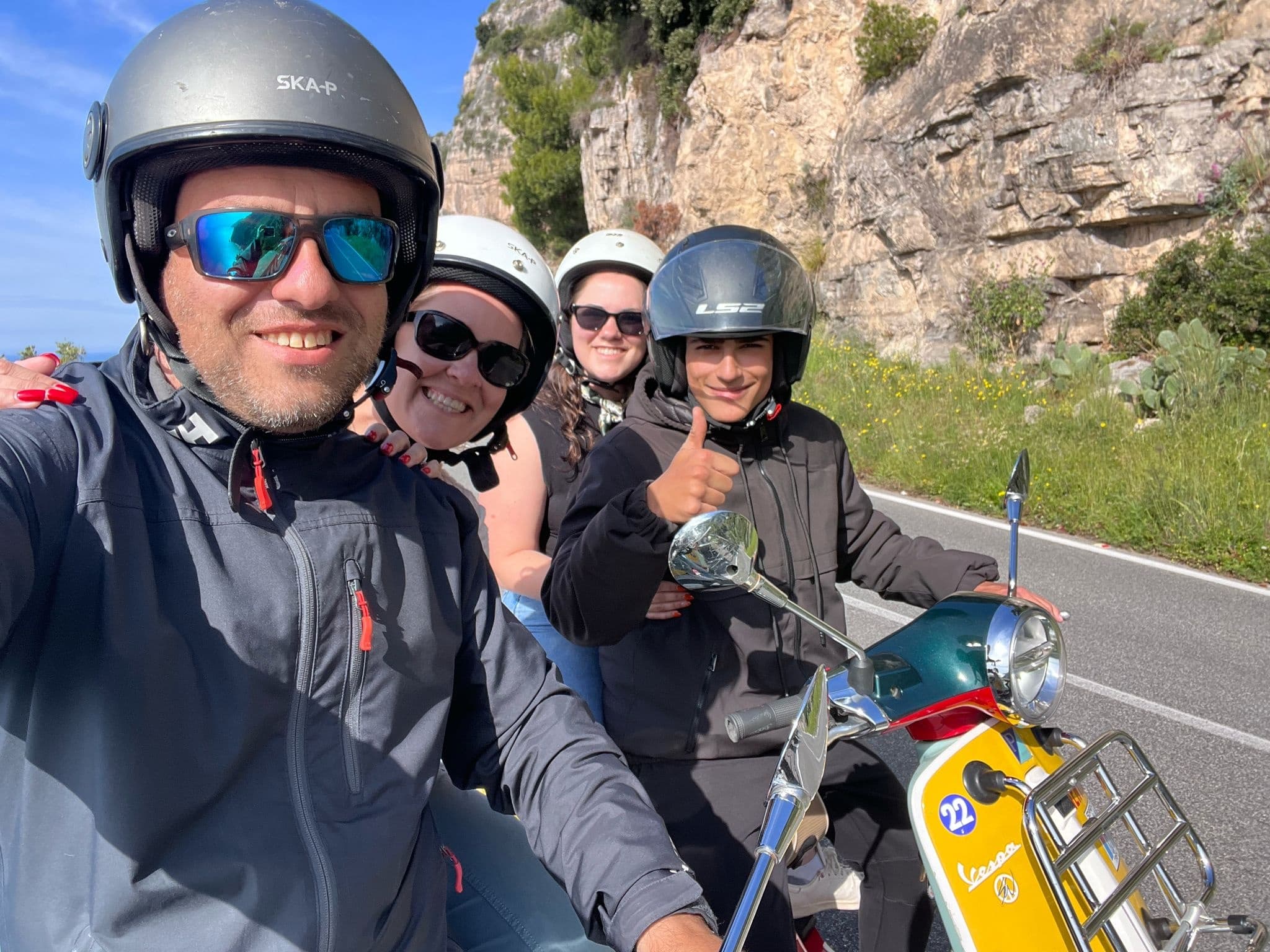 Friends on scooter tour taking selfie on coastal road