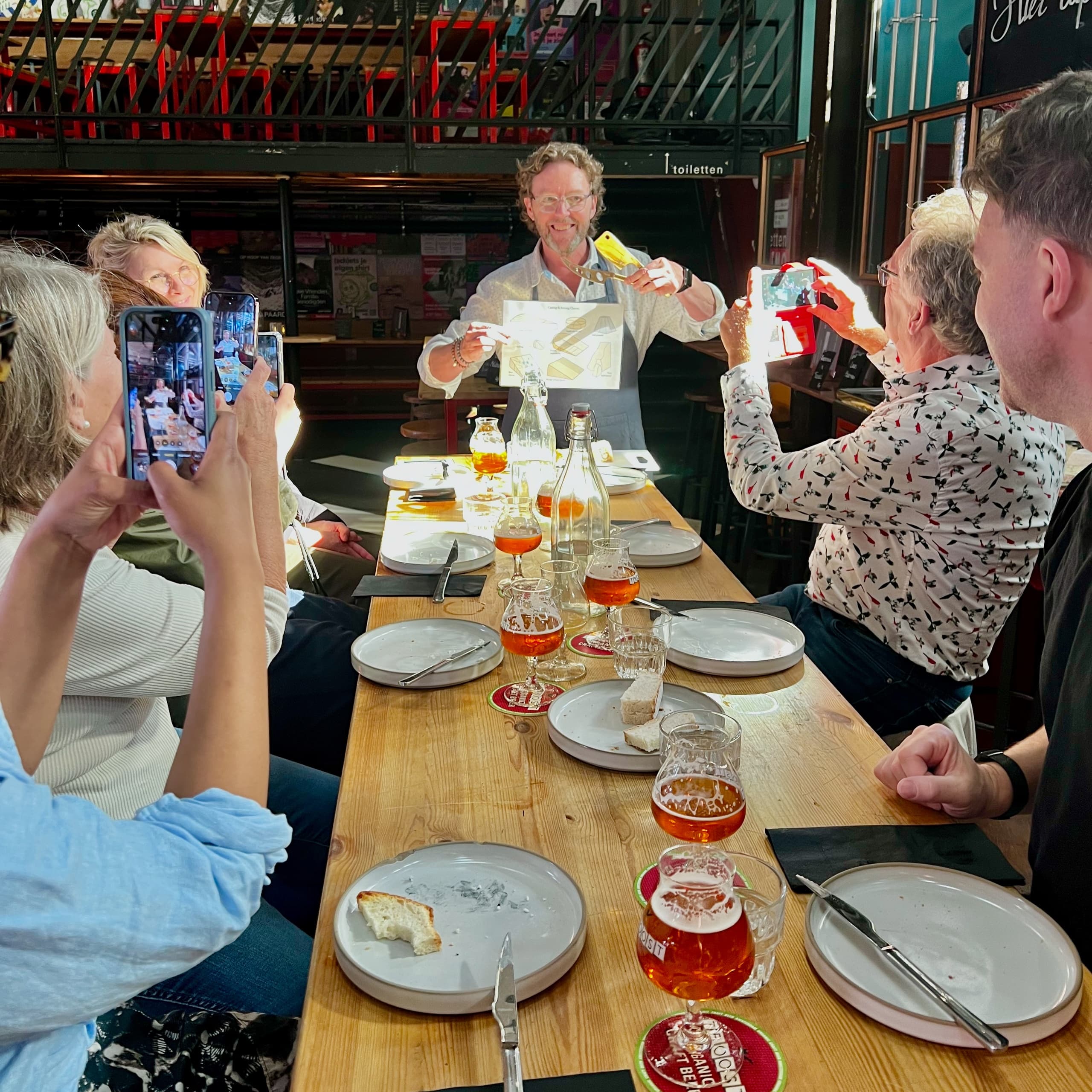 Group enjoying cheese and beer tasting at indoor market hall