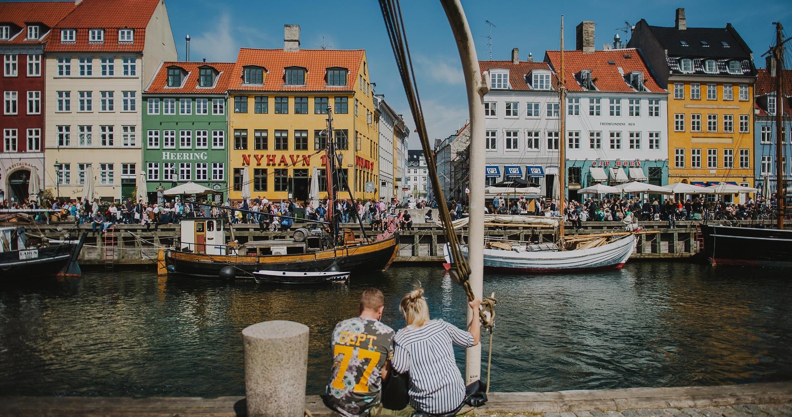 People enjoying Nyhavn harbor view on Copenhagen waterfront walking tour
