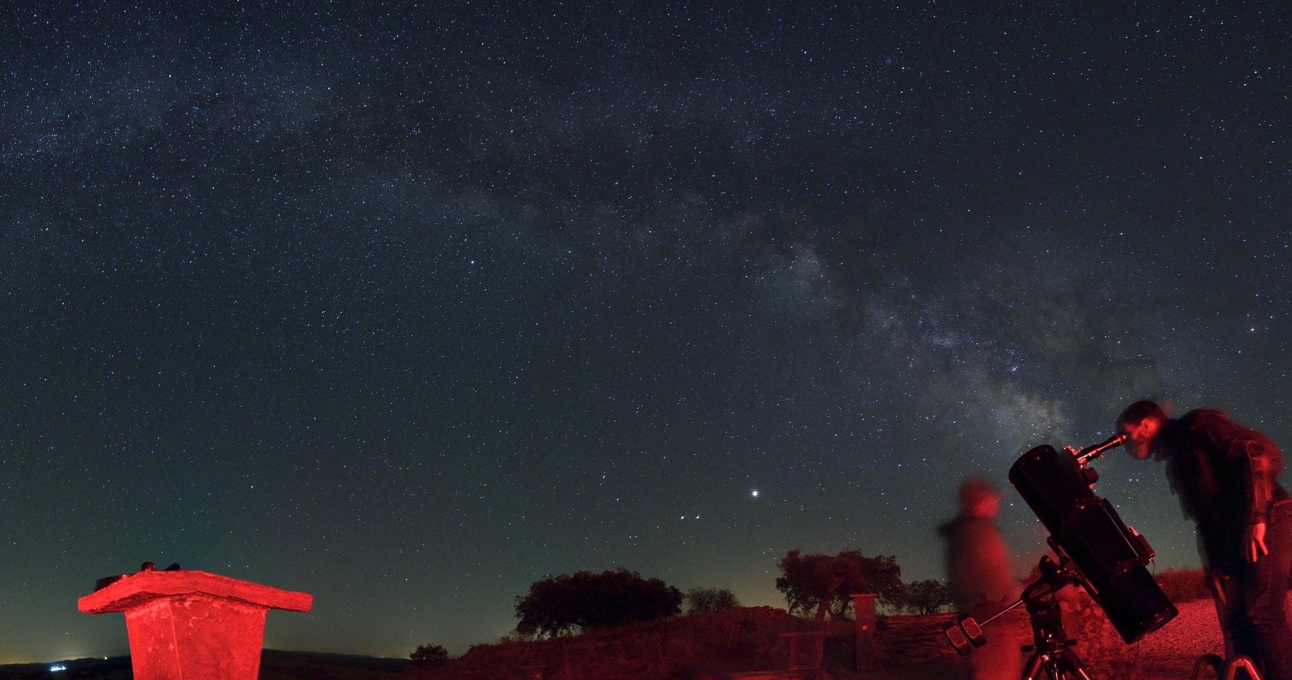 Telescopes and stargazers at a dark-sky site under Milky Way