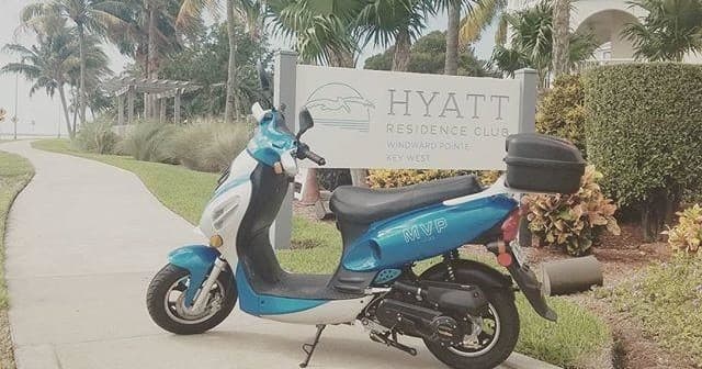 Blue rental scooter parked outside Hyatt residence, coastal stay