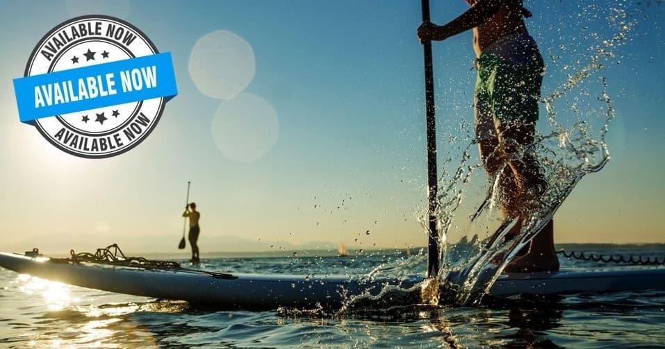 Sunrise paddleboard splash with rider on shimmering river water