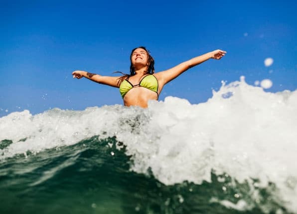 Surfer riding ocean wave on sunny Atlantic coast in Azores