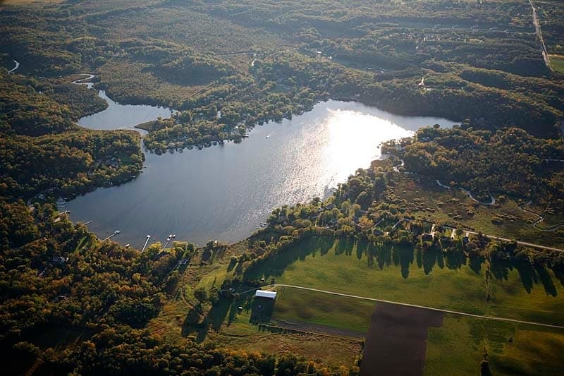 Aerial lake panorama showing paddling lake and forested shore