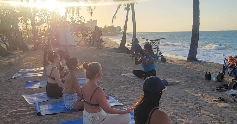 Sunset beach yoga and group gathering on sandy shoreline