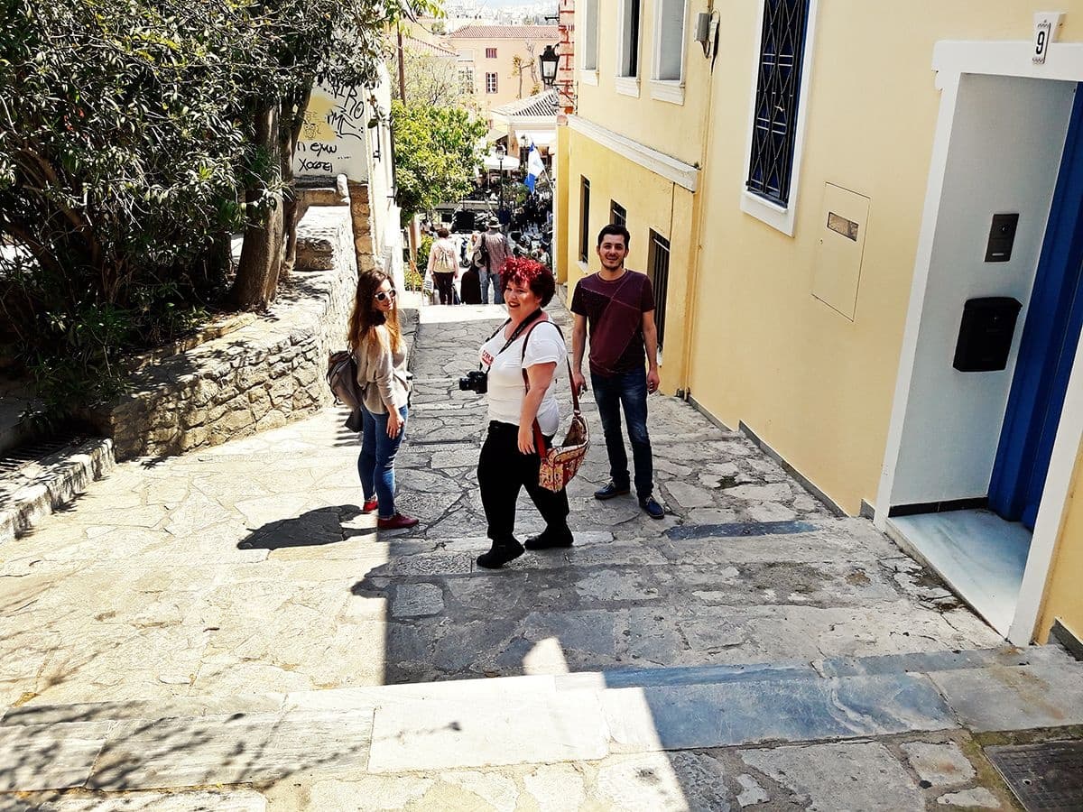 Small group climbing stone steps on Athens Plaka neighborhood tour