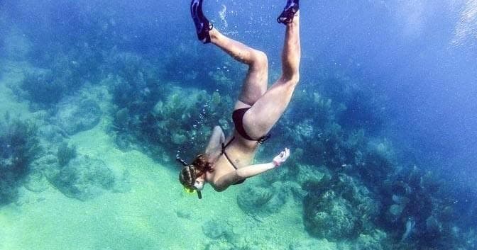 Underwater snorkeler exploring coral reef in clear tropical sea