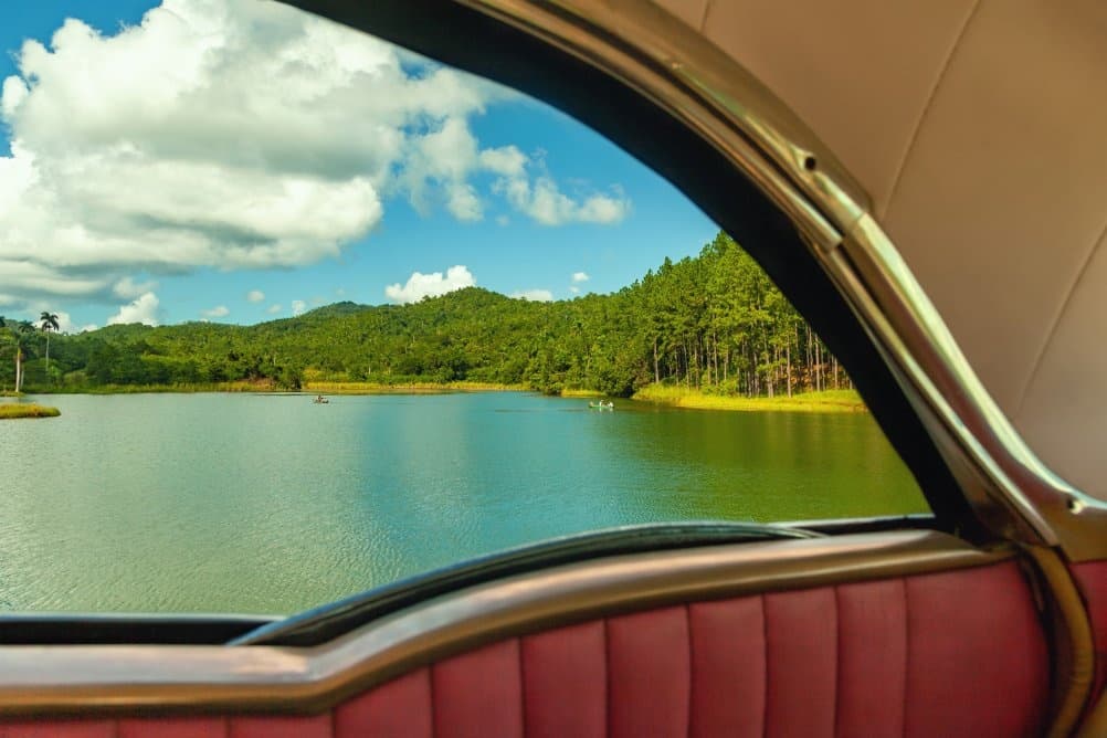Vintage car interior framing lakeside forest vista view