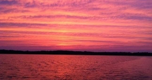 Sunset over Erie Canal waters with vibrant pink and purple sky