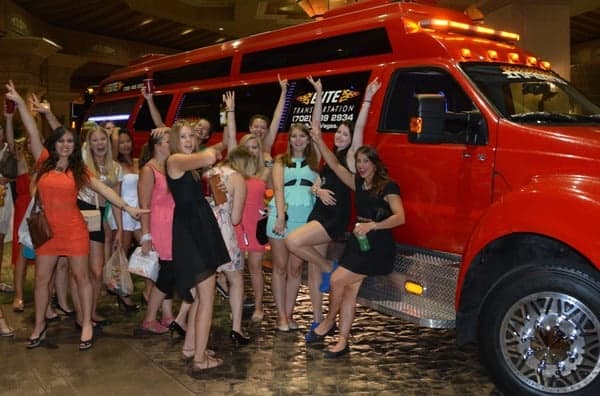 Group of women posing by red party bus at casino pickup