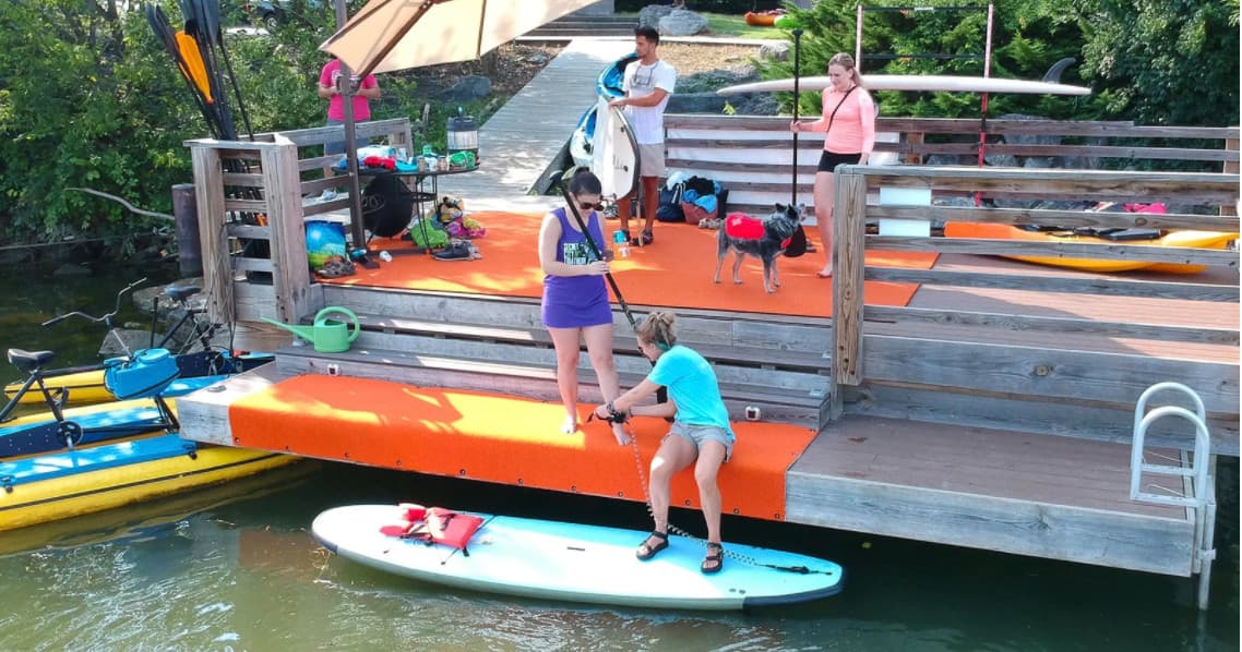 Families launching paddleboards and kayaks from wooden dock
