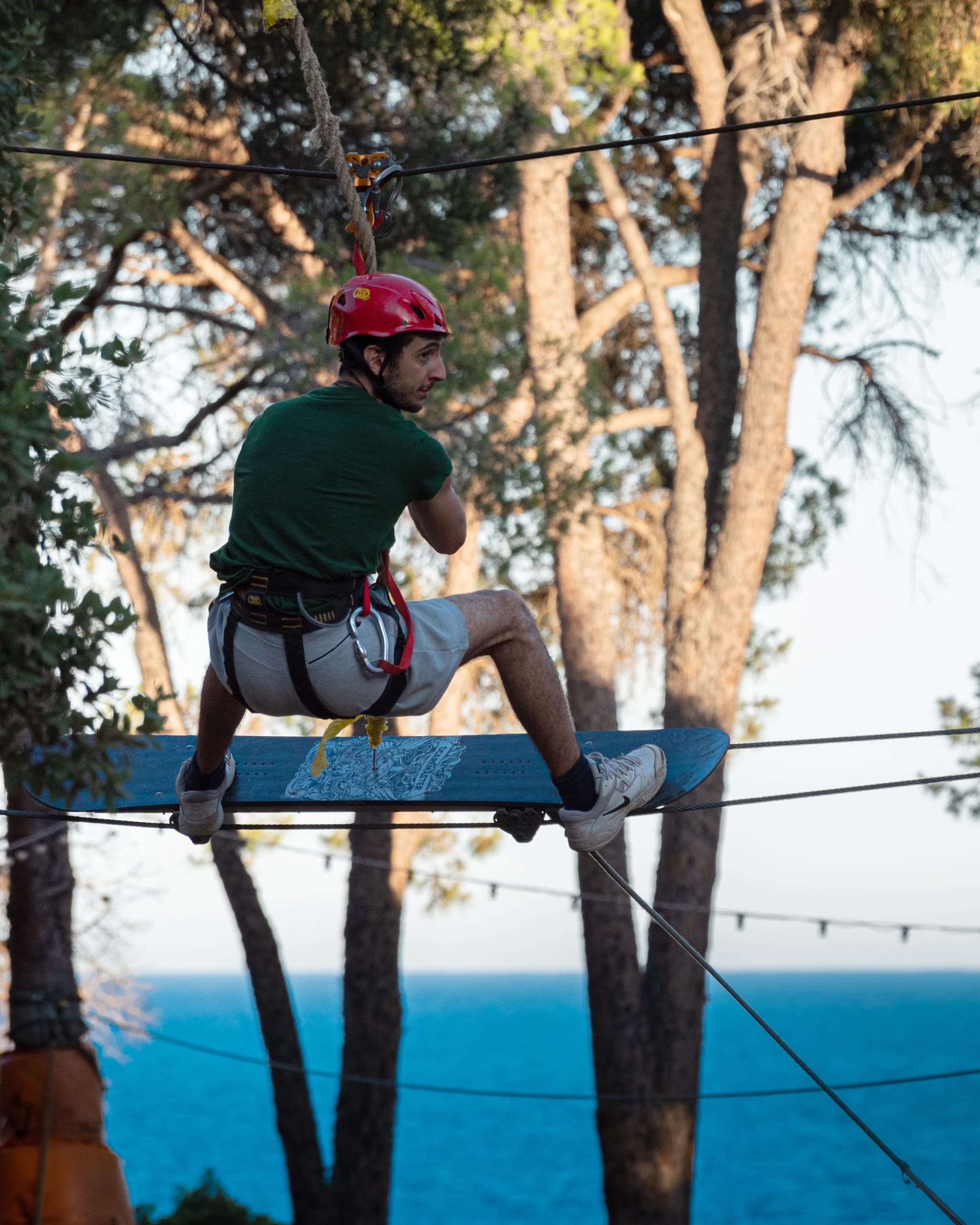 Participant seated on treetop platform with coastal sea view